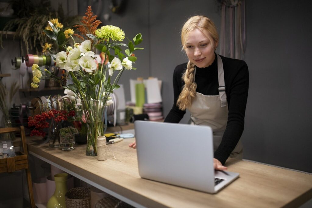 Właścicielka kwiaciarni pracuje na laptopie